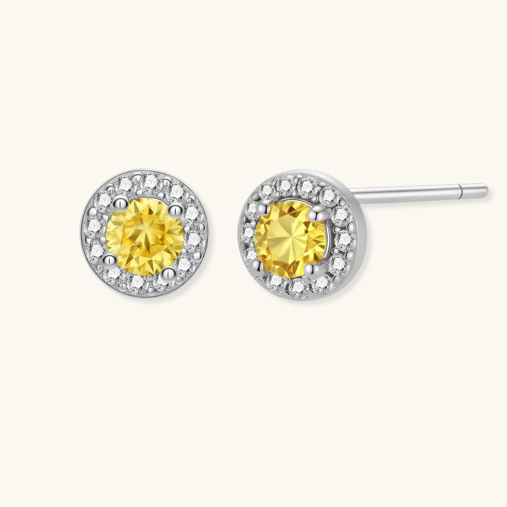 Dainty sterling silver stud earrings with yellow moissanite center stones surrounded by white halo stones