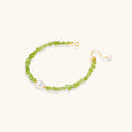 Delicate sterling silver bracelet with lime-green peridot gemstone chips and single freshwater pearl centerpiece