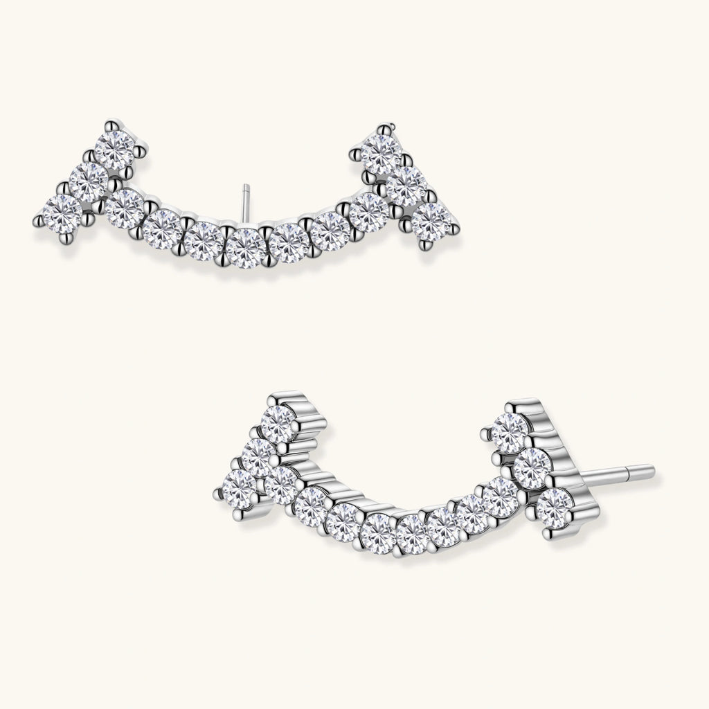 Curved sterling silver ear climbers with moissanite stones arranged in elegant arc shape on white background