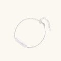 Minimalist bracelet with iridescent baroque pearl on rhodium-plated sterling silver chain against cream background