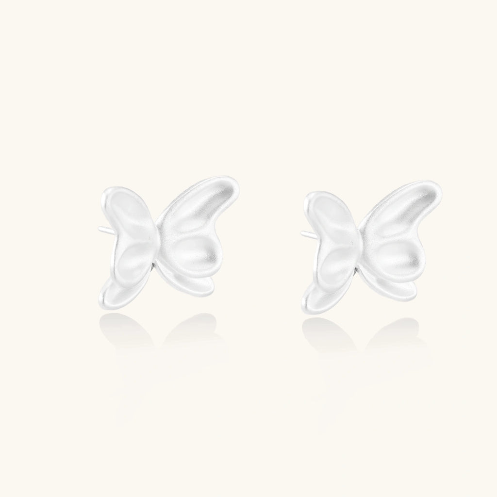Pair of translucent butterfly-shaped stud earrings with frosted finish and dimensional wing details on white background